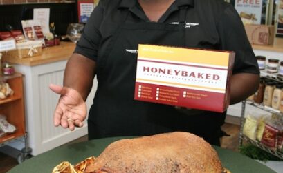 Les Pierce, owner of HoneyBaked Ham Cafe in Corpus Christi shows off one of his famous gold-foil wrapped hams, specially glazed with sugar and spice and everything nice! Photo by Carrie Robertson Meyer/Third Coast Photo