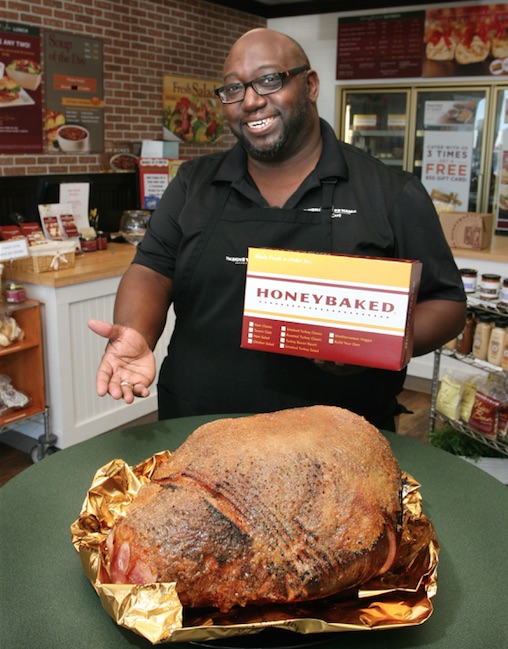 Les Pierce, owner of HoneyBaked Ham Cafe in Corpus Christi shows off one of his famous gold-foil wrapped hams, specially glazed with sugar and spice and everything nice! Photo by Carrie Robertson Meyer/Third Coast Photo