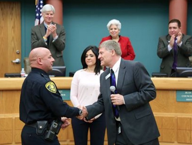 Newly appointed Chief of Police Mike Markle shakes hands with Corpus Christi City Manager Ron Olsen. In the background city council members and Mayor Nelda Martinez give Markle, who has been serving as interim chief since the death of Chief Floyd Simpson last year, a standing ovation. Photo courtesy CCPD