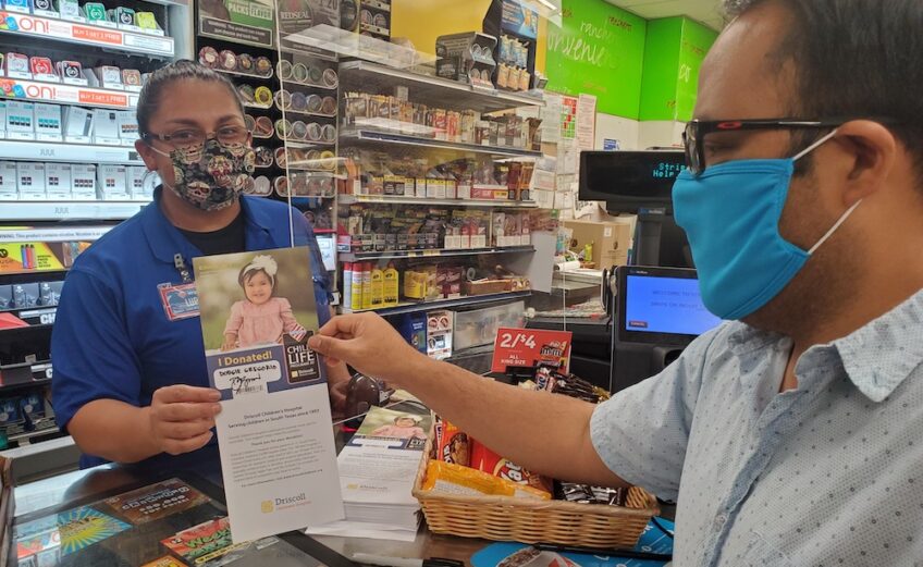 Stripes employee Lupe Lopez assists a customer with filling out the paper icon for Driscoll Children’s Hospital after donating to help sick and injured children in South Texas. Photo by Jane Kathleen Gregorio