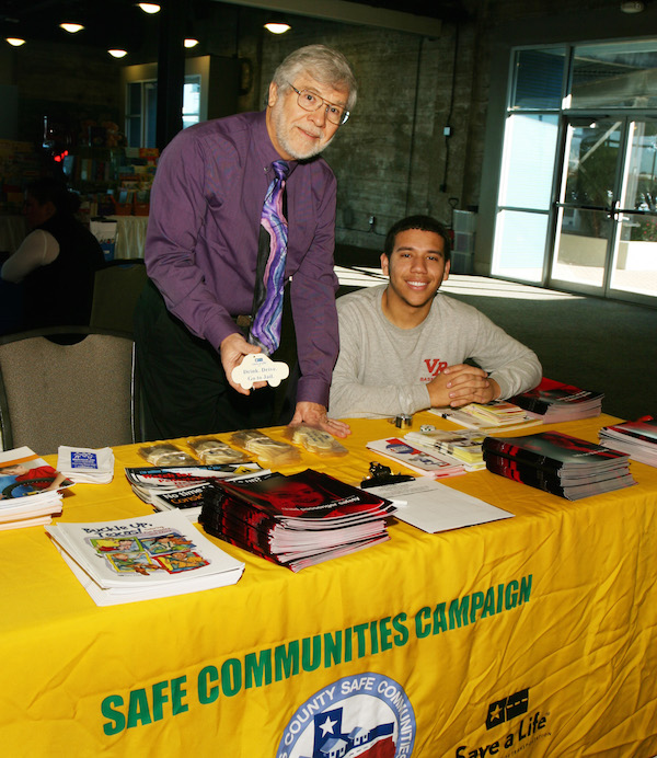 Dr. Philip Rhoades (left), professor of criminal justice at Texas A&M University-Corpus Christi, and Justin DeBouvier, 22, a political science major and student-worker at a recent health fair in the Ortiz Center in Corpus Christi. Rhodes is head of the Nueces County Safe Communities Campaign. Photo by Carrie Robertson Meyer/Third Coast Photo