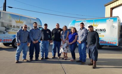 The family of service professionals at Drain King Plumbing, together with company owner Juan Sanches and his wife Rosa Sanches (center), who manages the office. Since acquiring their updated building at 1405 Neptune, they have continued to grow. Photo by Jane Kathleen Gregorio