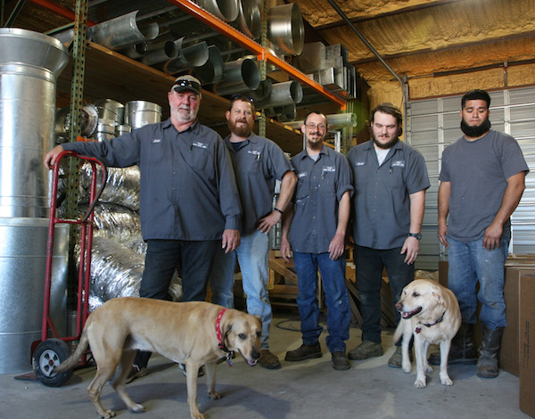 John Long at Long’s Heating and Air with Roni (left) and Honey Bunny (right). Long and his wife rescue dogs. Long calls Honey Bunny his “foster failure” since the objective was to find her a new home. She stayed with the Longs, instead, something they all seem pretty happy about. Photo by Carrie Robertson Meyer/Third Coast Photo