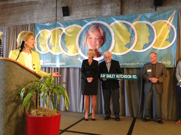 Former U.S. Senator Kay Bailey Hutchinson (podium) reacts with humble surprise when told that the La Quinta Trade Gateway Corridor has been renamed for her. The presentation was made at The State of the Port luncheon in Corpus Christi, the Hispanic Chamber of Commerce’s biggest fundraising event of the year. Photo by Suzanne Freeman