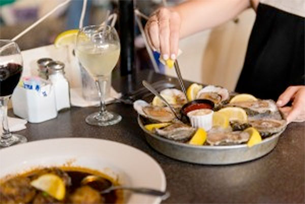 Customers at Water Street Seafood enjoy a plate of Gulf oysters on the half shell, a local speciality that is fairly scarce this season because of the closing of Copano Bay to harvesting. Oyster beds in the bay need the season break to rejuvenate says an expert at the Texas Parks and Wildlife Department. Courtesy Photo