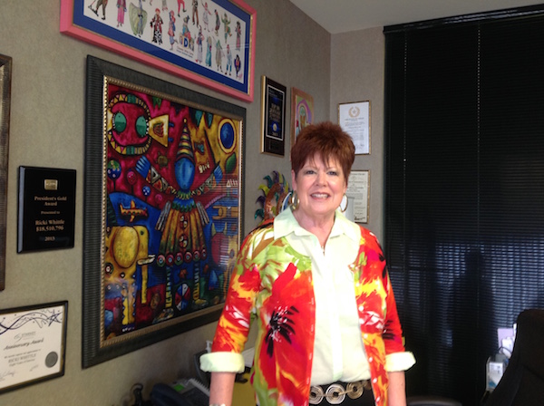 Ricki Whittle shows off a wall of business awards and colorful clown art in her office at Starkey Mortgage, 4215 Everhart in Corpus Christi. Photo by Suzanne Freeman