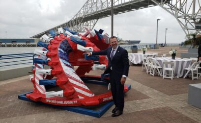 Port of Corpus Christi CEO Sean Strawbridge under the Harbor Bridge in Corpus Christi with a cutter-head dredging tool being used by the Great Lakes Dredge and Dock Company in the Corpus Christi Ship Channel. Photo from Dredging Contractors of America