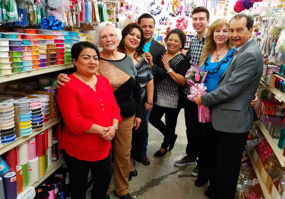 Standing among the colorful decor at Floro Distributing in Corpus Christi are (right to left) owner Greg Posada; his wife, Diana Posada; son, Andrew Posada; staff Yolanda Salinas, Adrian Alaniz, Alice Riojas, ‘Grandmother’ Matilda Rodriguez and Sandra Zamora. Photo by Jane Kathleen Gregorio