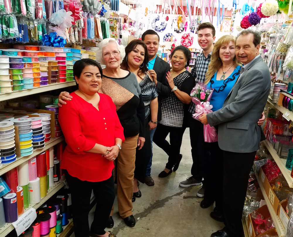 Standing among the colorful decor at Floro Distributing in Corpus Christi are (right to left) owner Greg Posada; his wife, Diana Posada; son, Andrew Posada; staff Yolanda Salinas, Adrian Alaniz, Alice Riojas, ‘Grandmother’ Matilda Rodriguez and Sandra Zamora. Photo by Jane Kathleen Gregorio