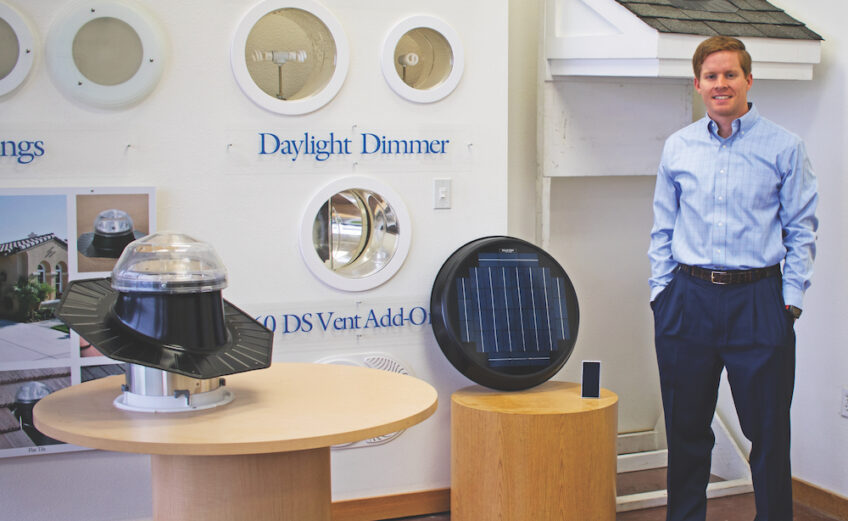 Sean Bean, managing partner of Sola-Lite LLC, in his San Antonio showroom with samples of how his product works. Shown are a Solatube lighting system from the roof to the designer light fixture in a room, and the solar-powered fan that keeps homes cooler with less electricity. Photo by Suzanne Freeman