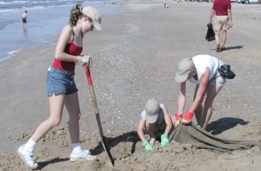 A family volunteers to clean beaches in the Coastal Bend during an Adopt-a-beach coastal wide cleanup.