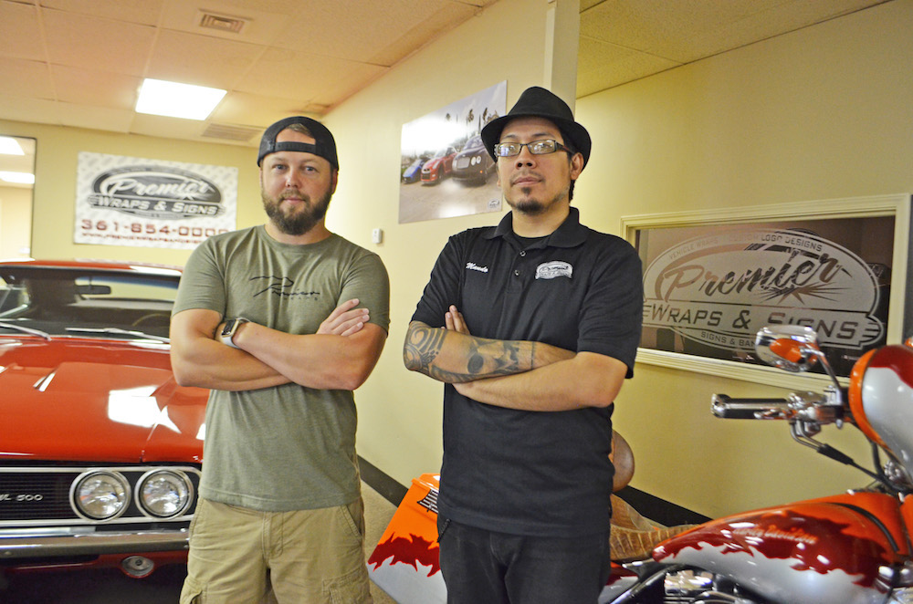 Premier Wraps & Signs General Manager John Frost and Graphic Production Manager and Designer Mando Lujan proudly showcase a few of their custom wraps and design in the showroom at 5626 Wooldridge Road in Corpus Christi. Photo by Jane Kathleen Gregorio.