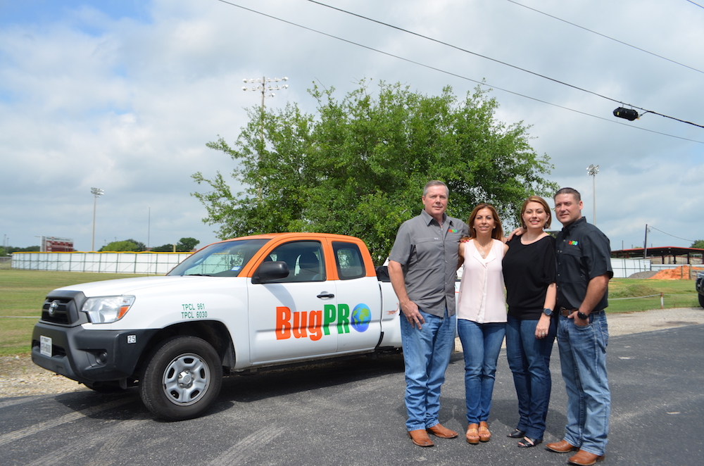 Buddy Lassmann (left) with his wife, Lamar, daughter, Amanda Brandt, and son-in-law, Shane Brandt. Lassmann consolidated the two names of his company into BugPro. The 33 BugPro professionals now wear matching uniforms and all drive white trucks with orange tops. Photo by Jane Kathleen Gregorio