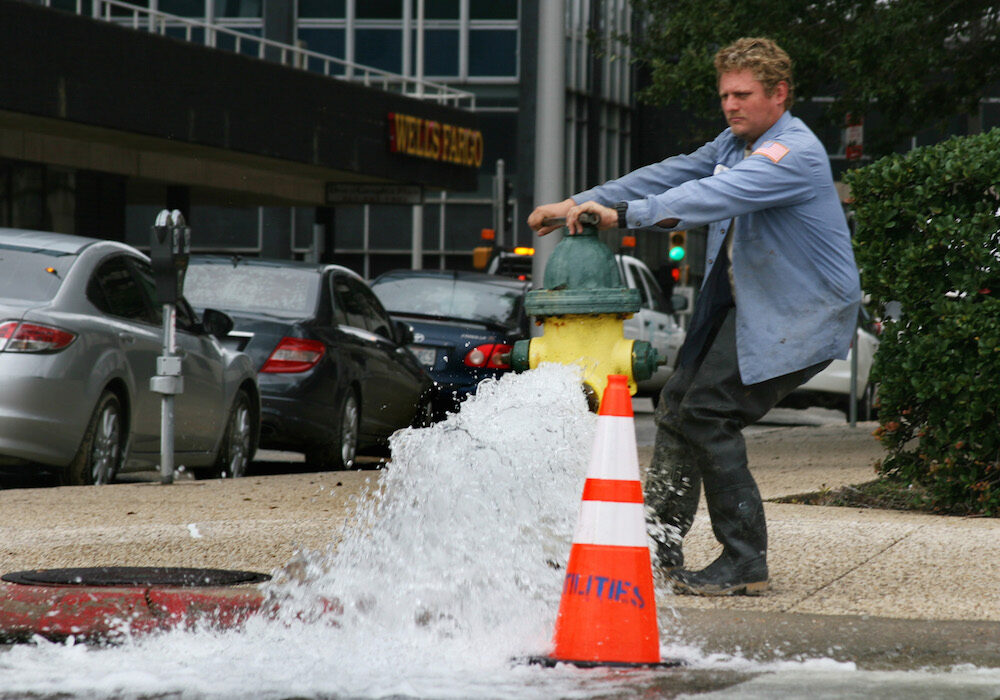 A city worker opens up a fire hydrant in December 2016 along S. Padre Island Drive. City water should smell and taste less like a swimming pool this week as the city returns to its routine water treatment process beginning May 1. Photo by Carrie Robertson Meyer