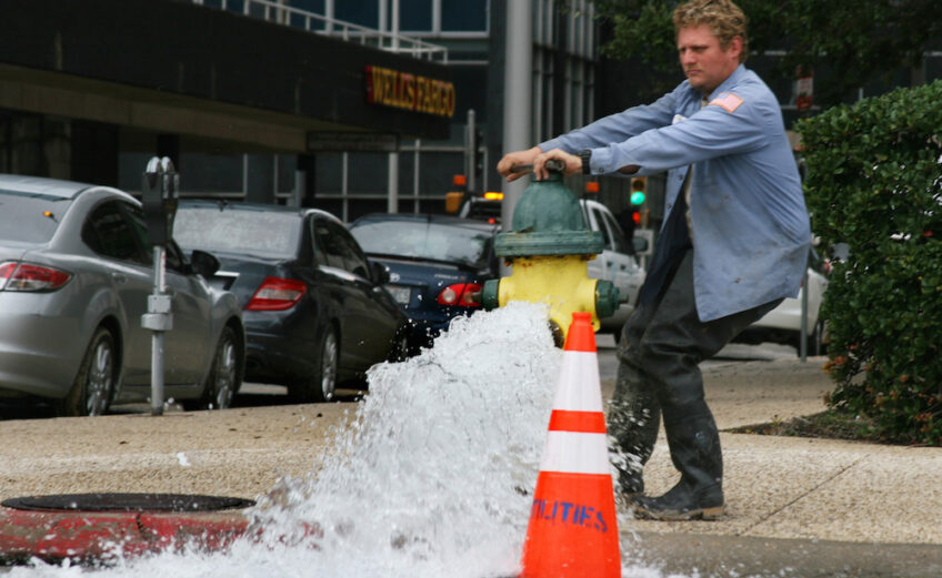 A city worker opens up a fire hydrant in December 2016 along S. Padre Island Drive. City water should smell and taste less like a swimming pool this week as the city returns to its routine water treatment process beginning May 1. Photo by Carrie Robertson Meyer