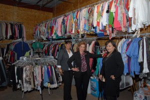 Standing in the holding room for the hundreds of suits and accessories donated to the new Dress for Success nonprofit are Melissa Canas (left), Cathy Colomo Riojas and Sylvia Burle. This is one of seven rooms of available clothing, along with two dressing rooms, that Riojas has donated from her business, Outside the Box, 4639 Corona in Corpus Christi. Staff photo